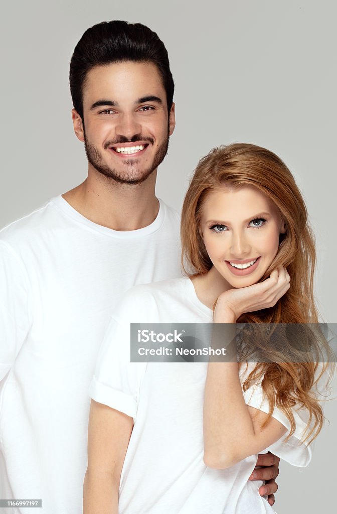 Happy youg couple posing together in studio. Beautiful young happy couple isolated on studio background. Facial expression, human emotions, advertising concept. Man and woman posing together.Love and friendship. Adult Stock Photo