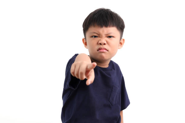 портрет разгневанного азиатского мальчика, указывая пальцем - anger child furious asian ethnicity стоковые фото и изображения