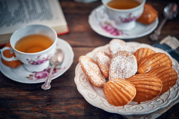 torte madeleine servite con tazza di tè - tea cakes foto e immagini stock