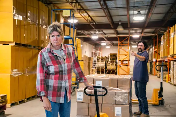 Photo of An industrial workplace bullying and harassment topic.  A male employee shouting and gesturing to a female coworker.