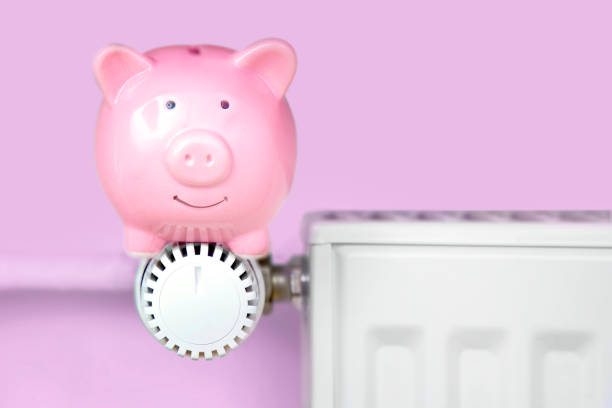 istock Piggy bank sitting on the heater 1167003207