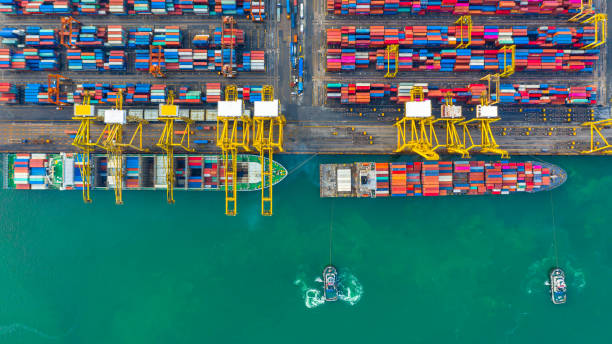 istock Container ship working at industrial port, Business import and export logistic and transportation of International by container ship in the open sea, Aerial view container ship loading and unloading. 1167003315