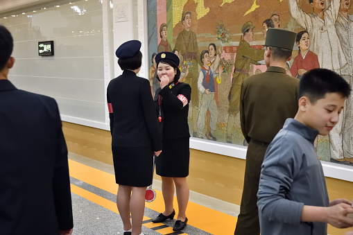 Pyongyang, North Korea - May 1, 2019: Girls staff in uniform at the Kaeson subway station. Pyongyang Metro