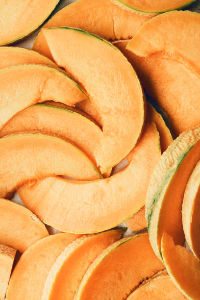 Summer bright orange melon background. Pieces of juicy fresh cantaloupe melon, flat lay, top view.
