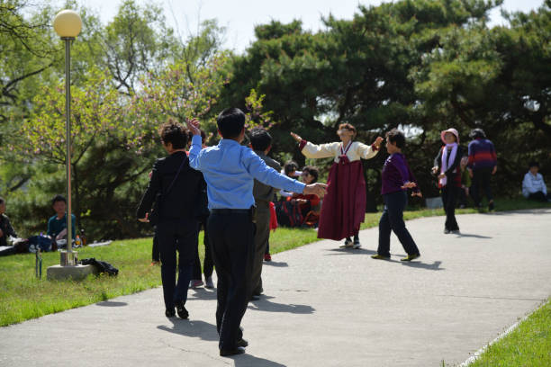 Pyongyang, North Korea - May 1, 2019: People relax and dance to music in the public park of city