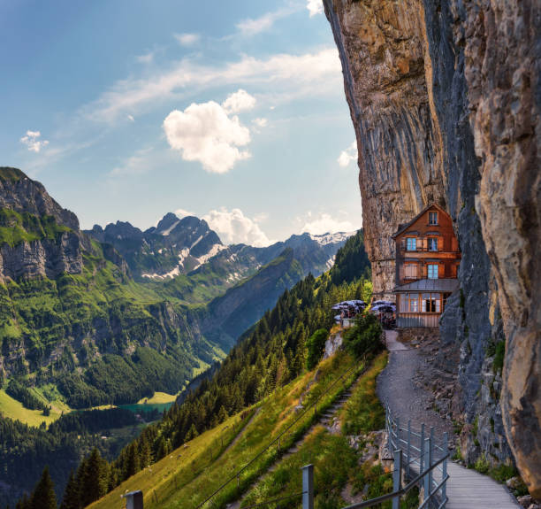 Swiss Alps and a restaurant under a cliff on mountain Ebenalp in Switzerland Swiss Alps and a mountain restaurant under the Ascher cliff viewed from mountain Ebenalp in the Appenzell region in Switzerland appenzell stock pictures, royalty-free photos & images