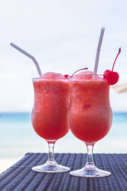 istock Two tropical coctails on a wattled table against the turquoise sea 1167010507