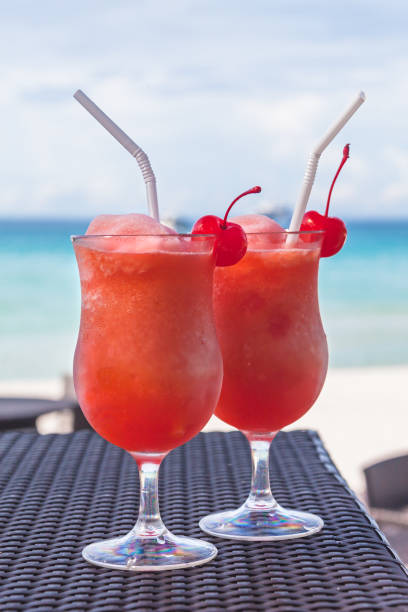 istock Two tropical coctails on a wattled table against the turquoise sea 1167010527