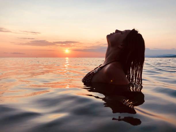 istock Woman enjoy sunset in the Ocean 1167010670