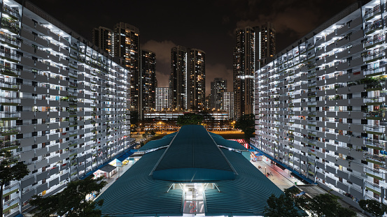 Toa Payoh housing estate in Singapore at night. A typical housing estate in Singapore with a wet market building in the middle and public flats surrounding it.