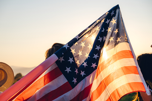 Spreading wide american flag at sunset.