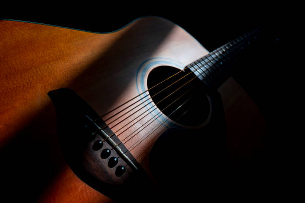 istock Acoustic guitar detail on black background 1167013713