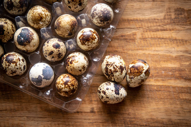Quail eggs in plastic container on wooden background from supermarket Quail eggs in plastic container on wooden background from supermarket quail egg stock pictures, royalty-free photos & images