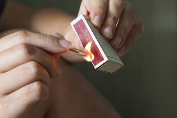 Woman striking a match Woman striking a match lit match stock pictures, royalty-free photos & images