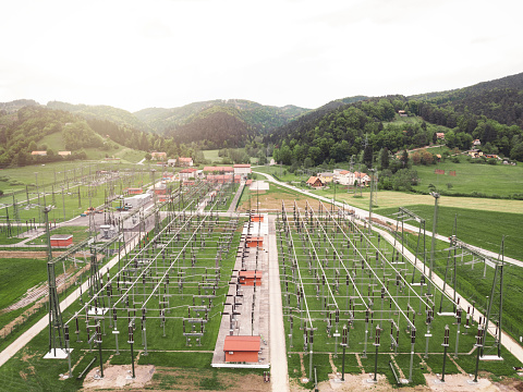 Aerial view of electrical substation. Electric power transmission  lines running across the towers, electric power being divided to go to different places. Electric power transmission center in the countryside.