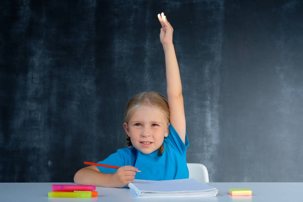 istock Schoolgirl raises her hand for an answer 1167022267