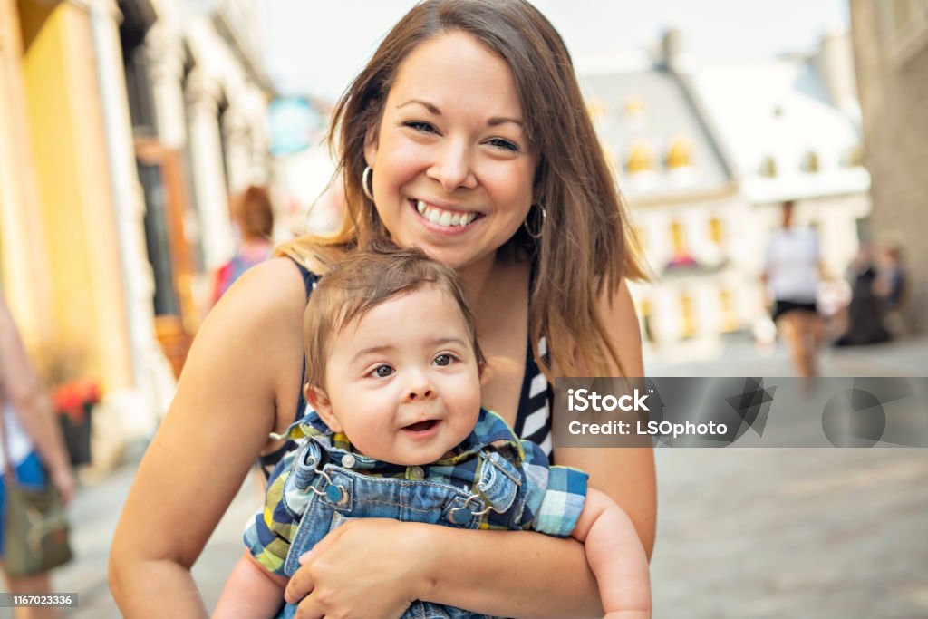 Una madre con il figlio piccolo su un ambiente urbano - Foto stock royalty-free di Abbracciare una persona Una madre con il figlio piccolo su un ambiente urbano - Foto stock royalty-free di Abbracciare una persona