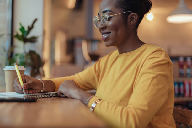 istock Young african american woman is writing notes 1167026243