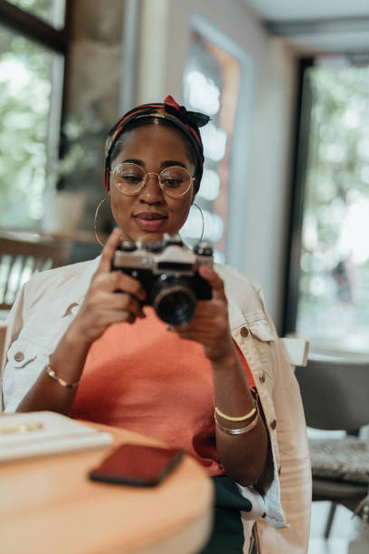 istock Young african american woman using photo camera 1167026298