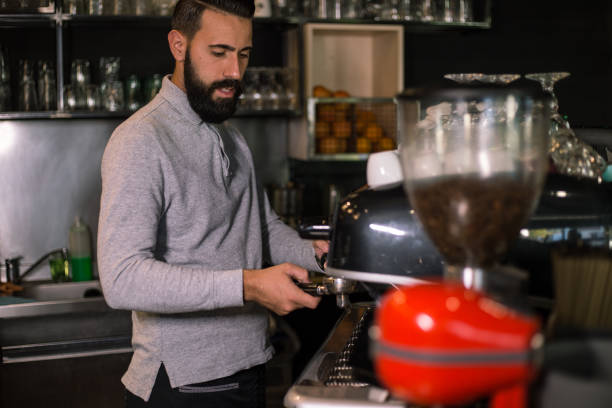 istock Bearded barista making coffee on the coffee machine 1167026369