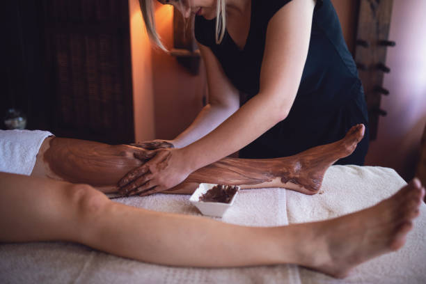 massage therapist using chocolate while working - chocolate spa treatment alternative therapy towel imagens e fotografias de stock