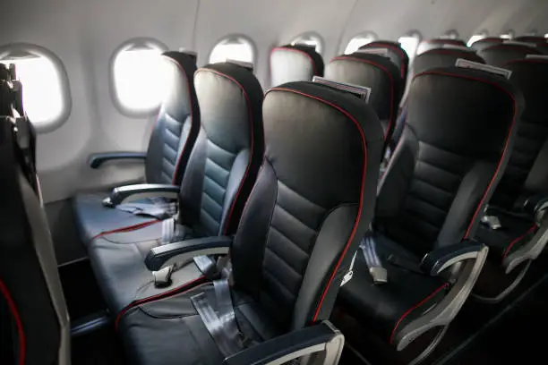 Photo of Airplane cabin seats with passengers. Economy class of new cheapest low-cost airlines without delay or cancellation of flight.