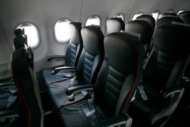 Photo of Airplane cabin seats with passengers. Economy class of new cheapest low-cost airlines without delay or cancellation of flight.