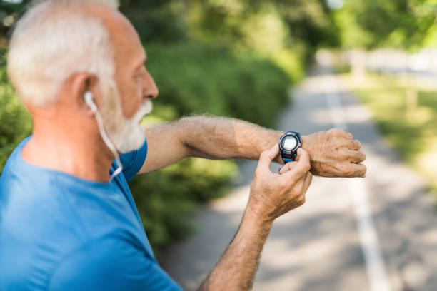 istock Senior man using digital watch outdoors. 1167030535