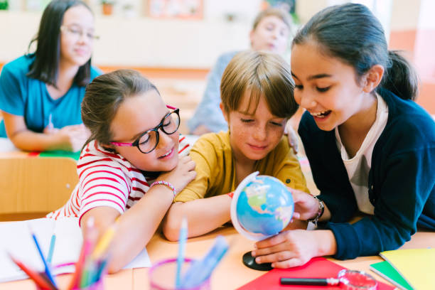 istock School children studying geography on globe 1167031853