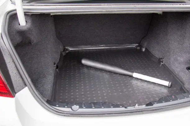 Plastic baseball-bat in the luggage compartment of a car, self-defense concept