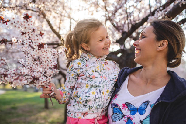 istock Cheerful mother and daughter under a blossoming tree 1167033098