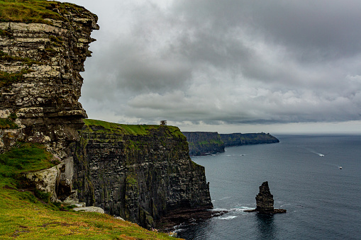 Irish countryside view on the Cliffs of Moher and the Branaunmore sea stack, geosites and geopark, Wild Atlantic Way, wonderful spring cloudy day in county Clare in Ireland