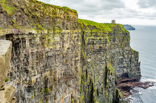 Breathtaking view of a vertical wall of the Cliffs of Moher, geosites and geopark, Wild Atlantic Way, wonderful spring cloudy day in county Clare in Ireland