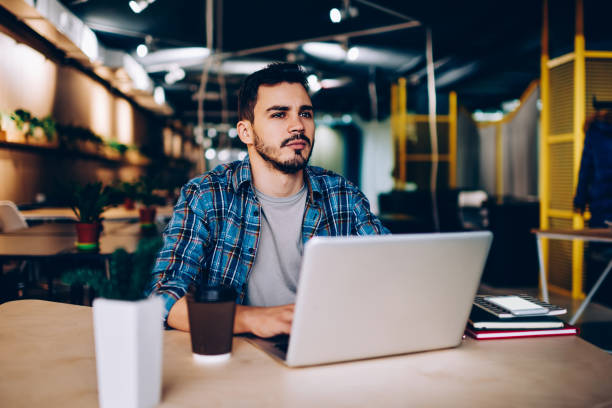 istock Thoughtful male freelancer pondering on idea for working project sitting with laptop computer in coworking space,contemplative young student using netbook and wifi in college library for learning 1167038420
