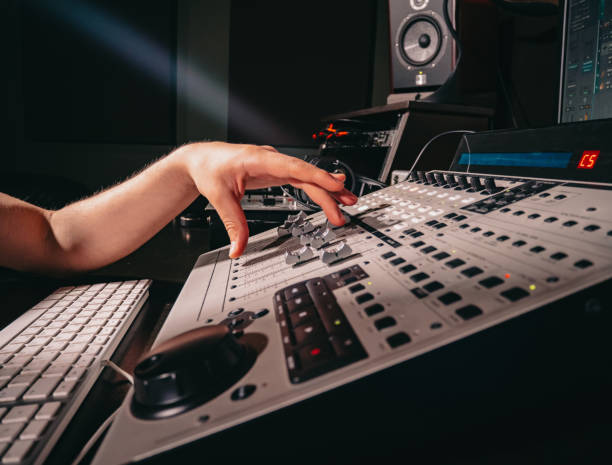istock Unrecognizable sound producer or engineer rotates scrolls wheel on mixing console in professional recording studio. Musician working on new song. Hands close up. 1167039322