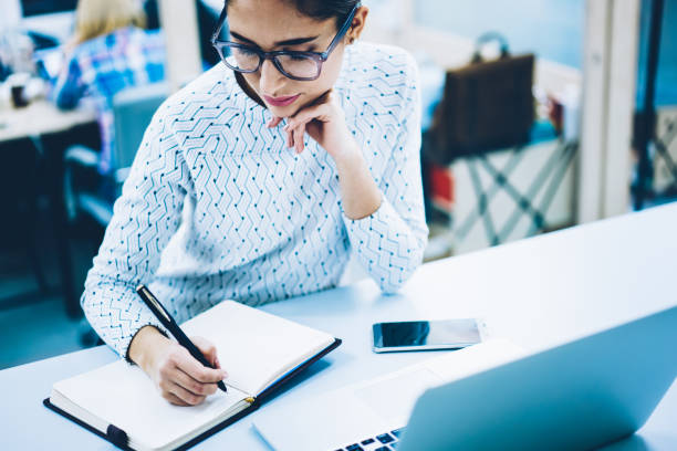 istock Cropped image on businesswoman writing statement for startup project concentrated on idea at desktop, female administrative assistant making notes of working planning organizing information 1167039686