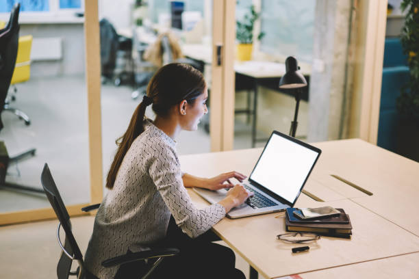 istock Businesswoman sitting at desktop late in evening creating plan for startup using laptop computer with mock up screen,female manager completing work before deadline staying overtime in office 1167040944