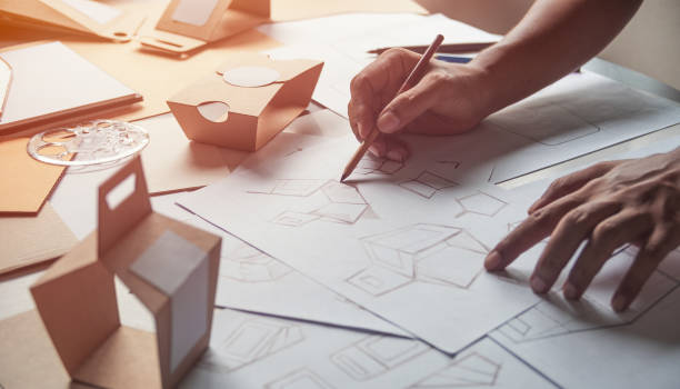 istock Designer sketching drawing design Brown craft cardboard paper product eco packaging mockup box development template package branding Label . designer studio concept . 1167040954