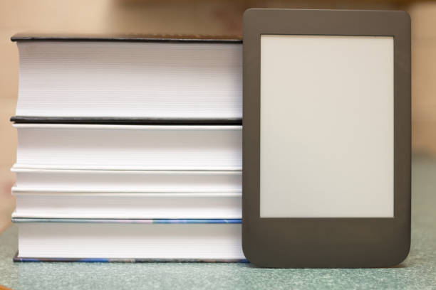 istock Modern e-book on the background of a stack of thick paper books. Close-up with selective focus. Training and technology concept 1167041268