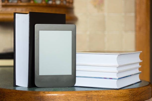 istock Modern e-book on the background of a stack of thick paper books. Close-up with selective focus. Training and technology concept 1167041272
