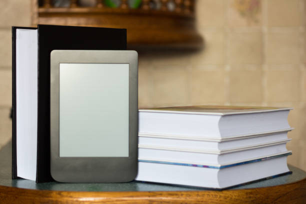 istock Modern e-book on the background of a stack of thick paper books. Close-up with selective focus. Training and technology concept 1167041884