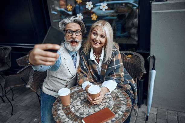 Taking funny selfies in cafe stock photo