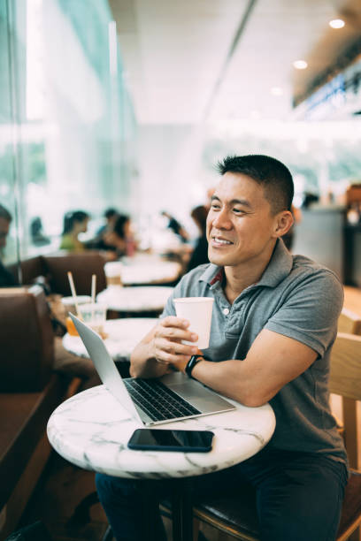 istock Businessman drinking coffee in bar and working on laptop 1167047463