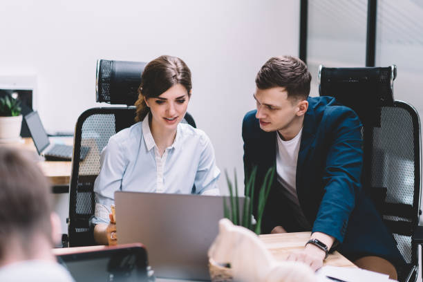 istock Male and female colleagues watching tutorial on website and discussing working plan on modern laptop device with wireless internet connection.Two IT developers installing app collaborating in office 1167050465