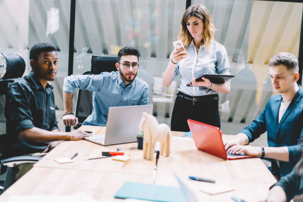 istock Diverse group of young people in formal wear using modern technology for productive work in office.Team of male and female designers collaborating on project,Cooperative process during brainstorming 1167050481