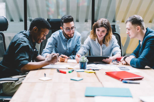 istock Multicultural group of professional designers in formal wear collaborating on task using modern touch pad device with wireless internet connection during brainstorming meeting in office interior 1167050485