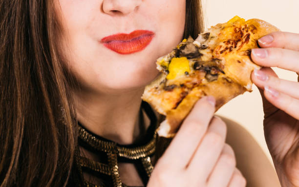 istock Woman eating hot pizza slice 1167051694