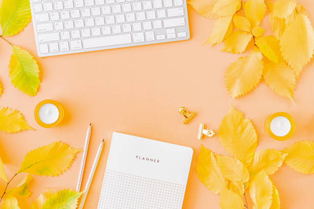 istock Flat lay blogger or freelancer workspace with a planner, keyboard, colorful autumn leaves on a color background 1167051756