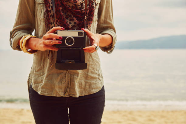 istock Attractive woman holding camera on the tropical beach. 1167053211