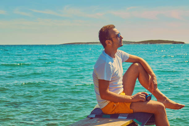 istock Attractive man holding camera on the tropical beach. 1167055350